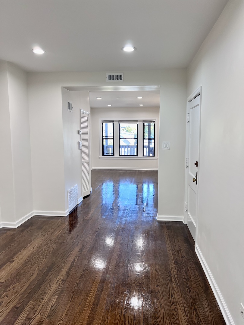 3051 North Racine Avenue, Unit 3F Chicago, IL 60657 - Photo 12 of 21 a view of an empty room with wooden floor and a window