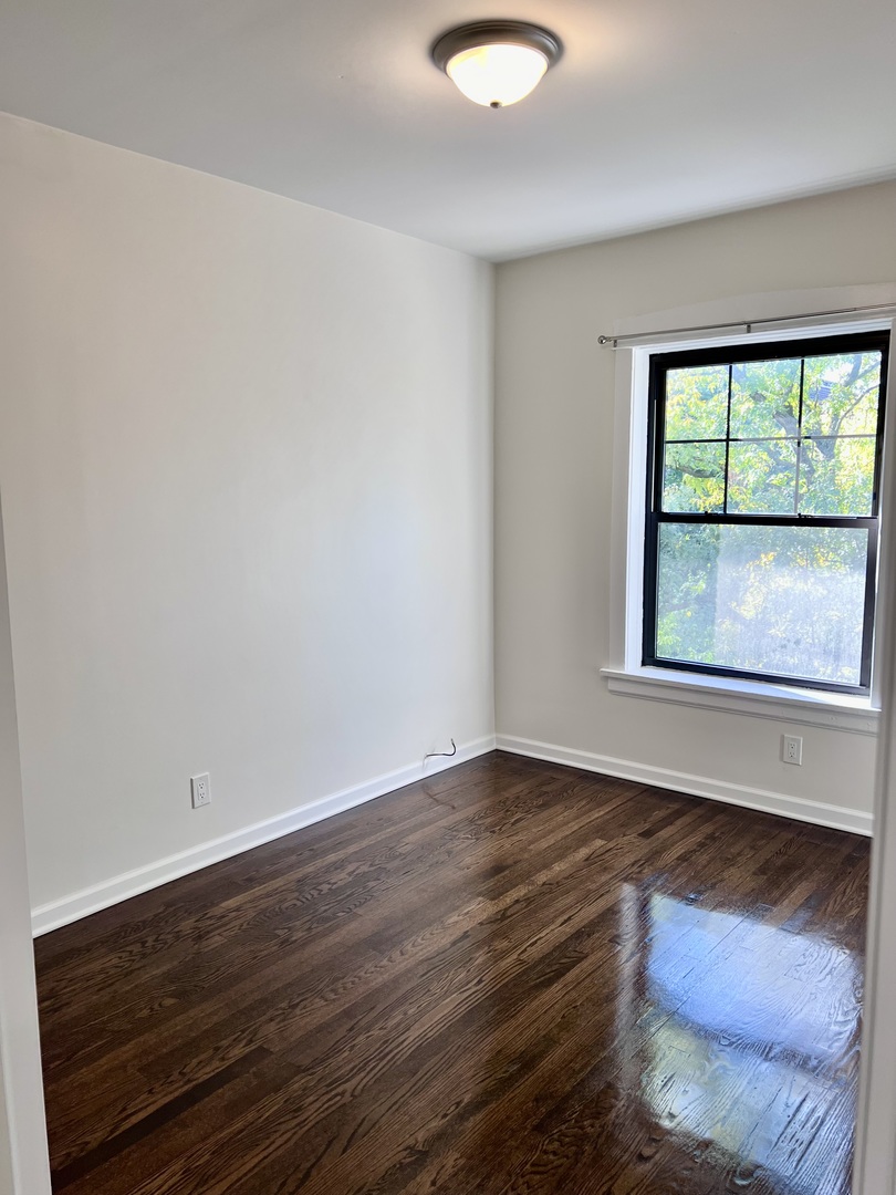 3051 North Racine Avenue, Unit 3F Chicago, IL 60657 - Photo 13 of 21 a view of an empty room with wooden floor and a window