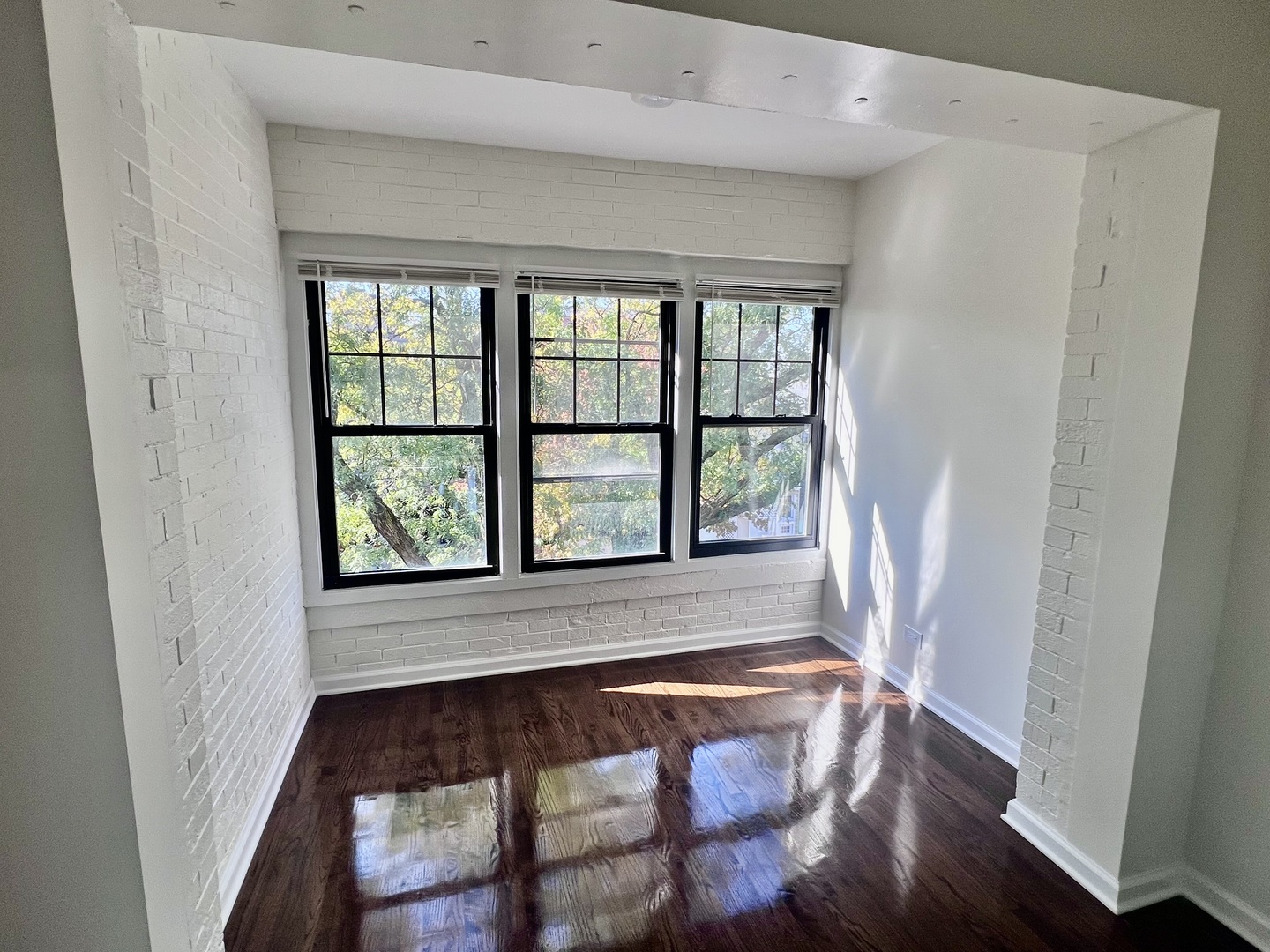 3051 North Racine Avenue, Unit 3F Chicago, IL 60657 - Photo 17 of 21 a view of an empty room with wooden floor and a window