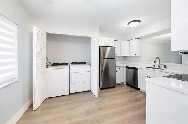 a kitchen with a refrigerator sink and cabinets