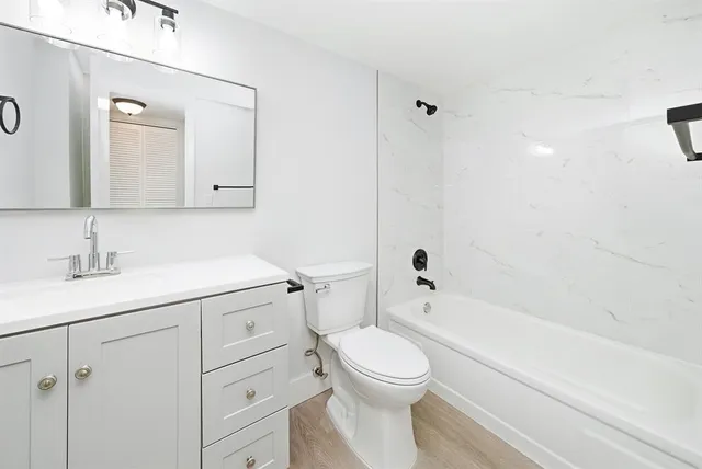 a bathroom with a sink a toilet and shower