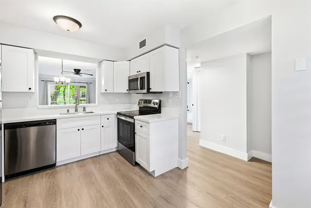 a kitchen with stainless steel appliances a white stove top oven a sink and a refrigerator