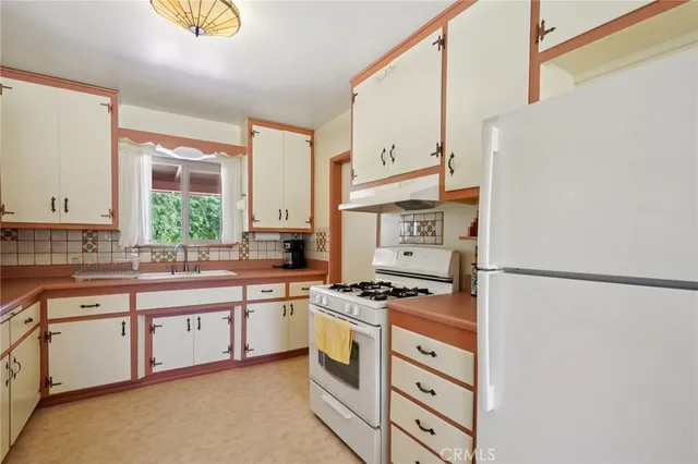a kitchen with stainless steel appliances a stove a sink and a refrigerator