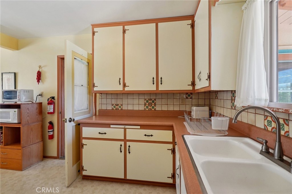 61494 Sunburst Drive Joshua Tree, CA 92252 - Photo 13 of 31 a kitchen with stainless steel appliances granite countertop a sink and a refrigerator