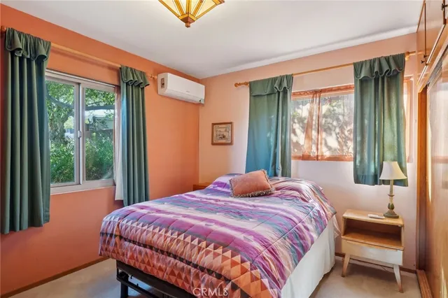 a bedroom with a bed and a large window with outer view