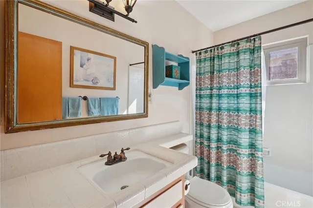 a bathroom with a sink vanity mirror and toilet