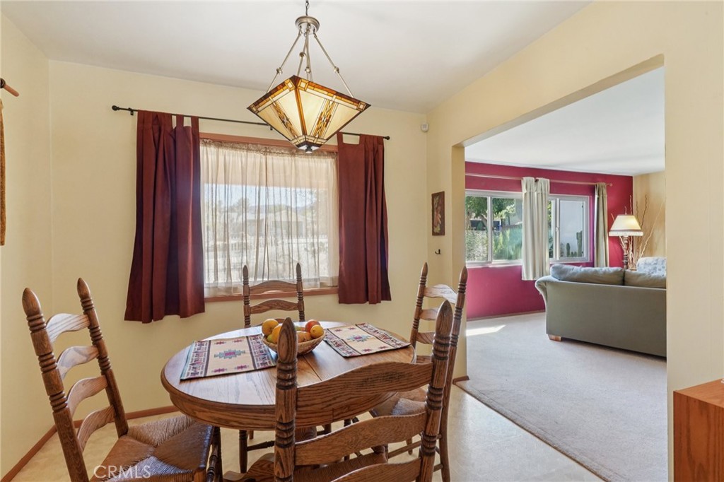 61494 Sunburst Drive Joshua Tree, CA 92252 - Photo 9 of 31 a living room with furniture a flat screen tv and a chandelier