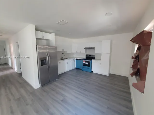 a view of a kitchen with wooden floor and electronic appliances