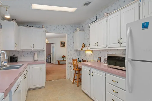 a kitchen with white cabinets and white appliances