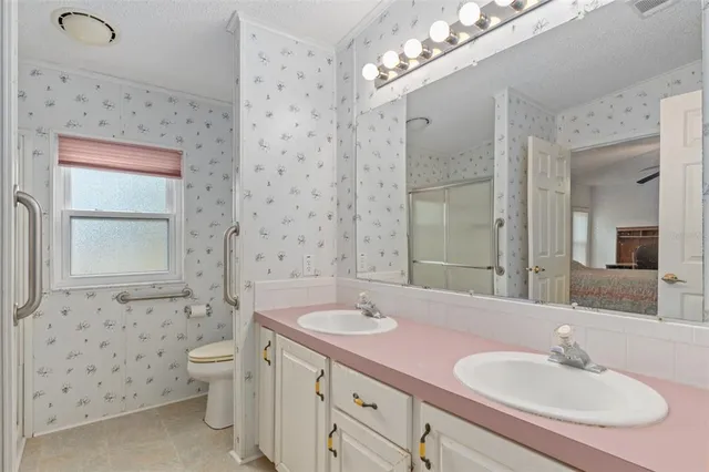 a bathroom with a double vanity sink mirror and toilet