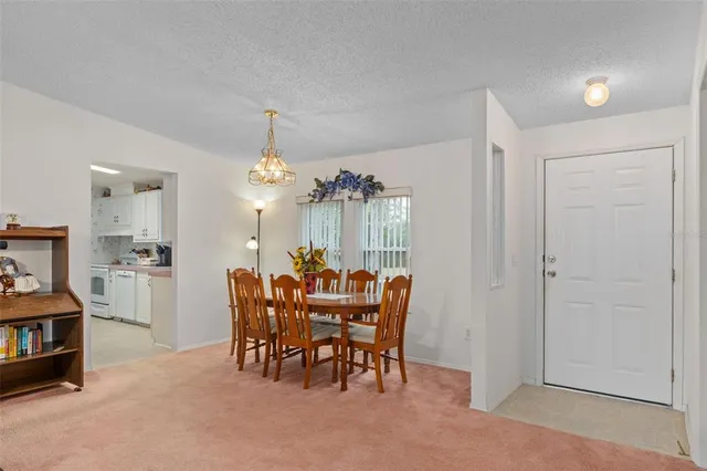 a view of a dining room with furniture and chandelier