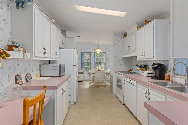 a kitchen with stainless steel appliances sink a stove and cabinets