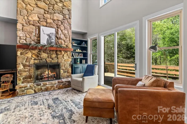 a living room with furniture a large window and a fireplace