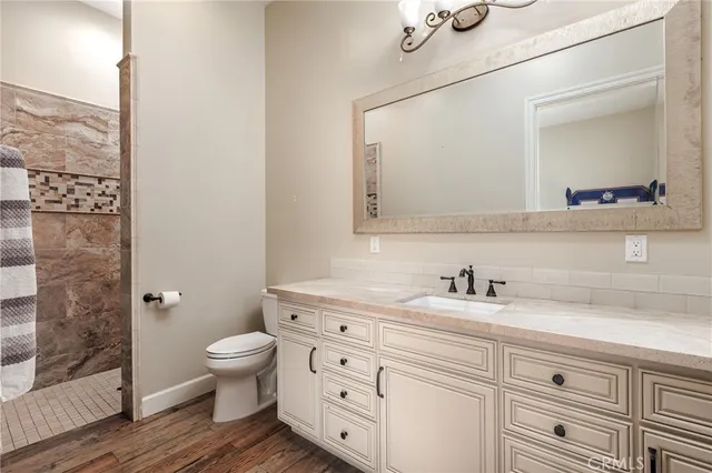 a bathroom with a granite countertop toilet sink and mirror
