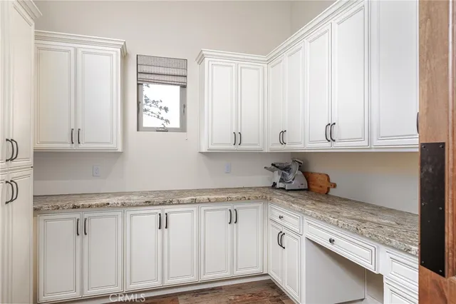 a kitchen with granite countertop white cabinets and a sink