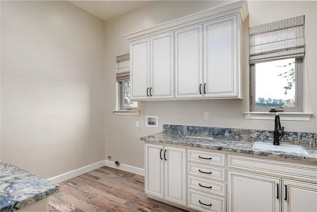 a kitchen with granite countertop white cabinets and a sink