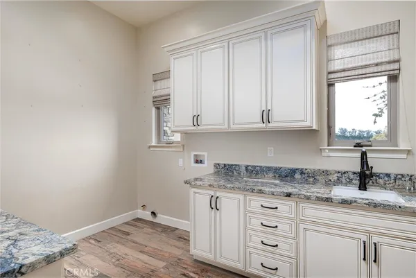 a kitchen with granite countertop white cabinets and a sink