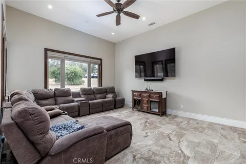 a living room with furniture a flat screen tv and a window