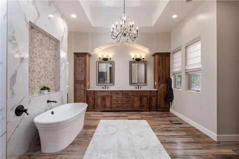 a bathroom with a tub sink shower and mirror