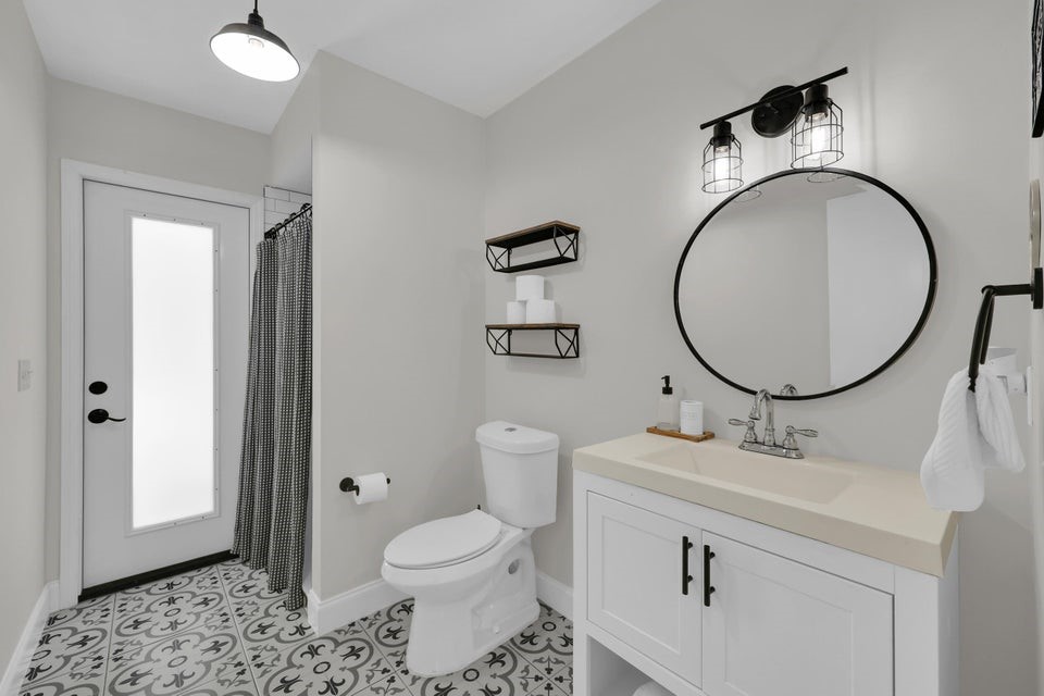 1950 Southwest Logwood Road Port St. Lucie, FL 34953 - Photo 20 of 32 a bathroom with a toilet a sink and a mirror