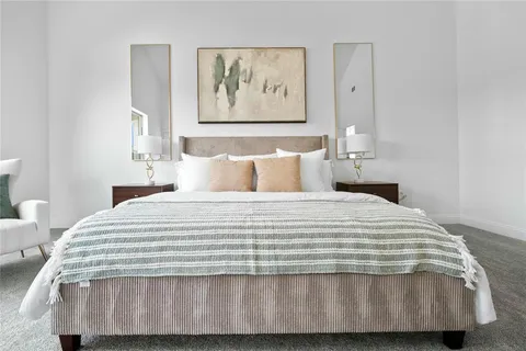 a bedroom with a bed and painting on the wall