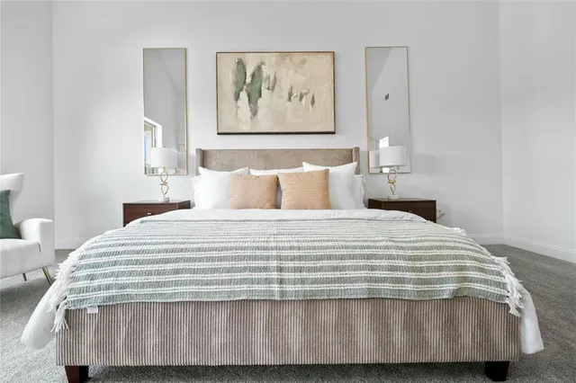 a bedroom with a bed and painting on the wall