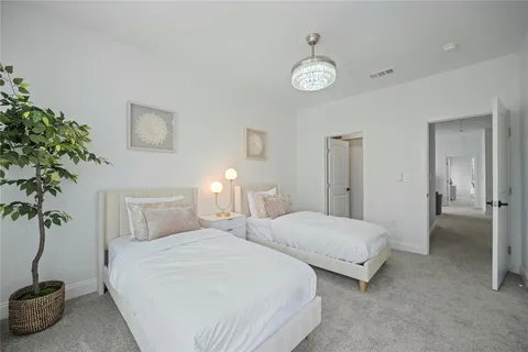 a bedroom with two beds and a potted plant