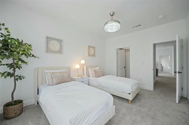 a bedroom with two beds and a potted plant