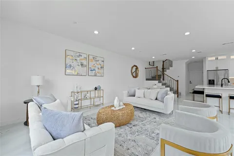 a living room with furniture and a view of kitchen