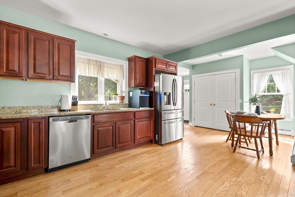109 Read Street Somerset, MA 02726 - Photo 18 of 42 a kitchen with stainless steel appliances granite countertop a stove a sink dishwasher a microwave oven and a dining table with wooden floor