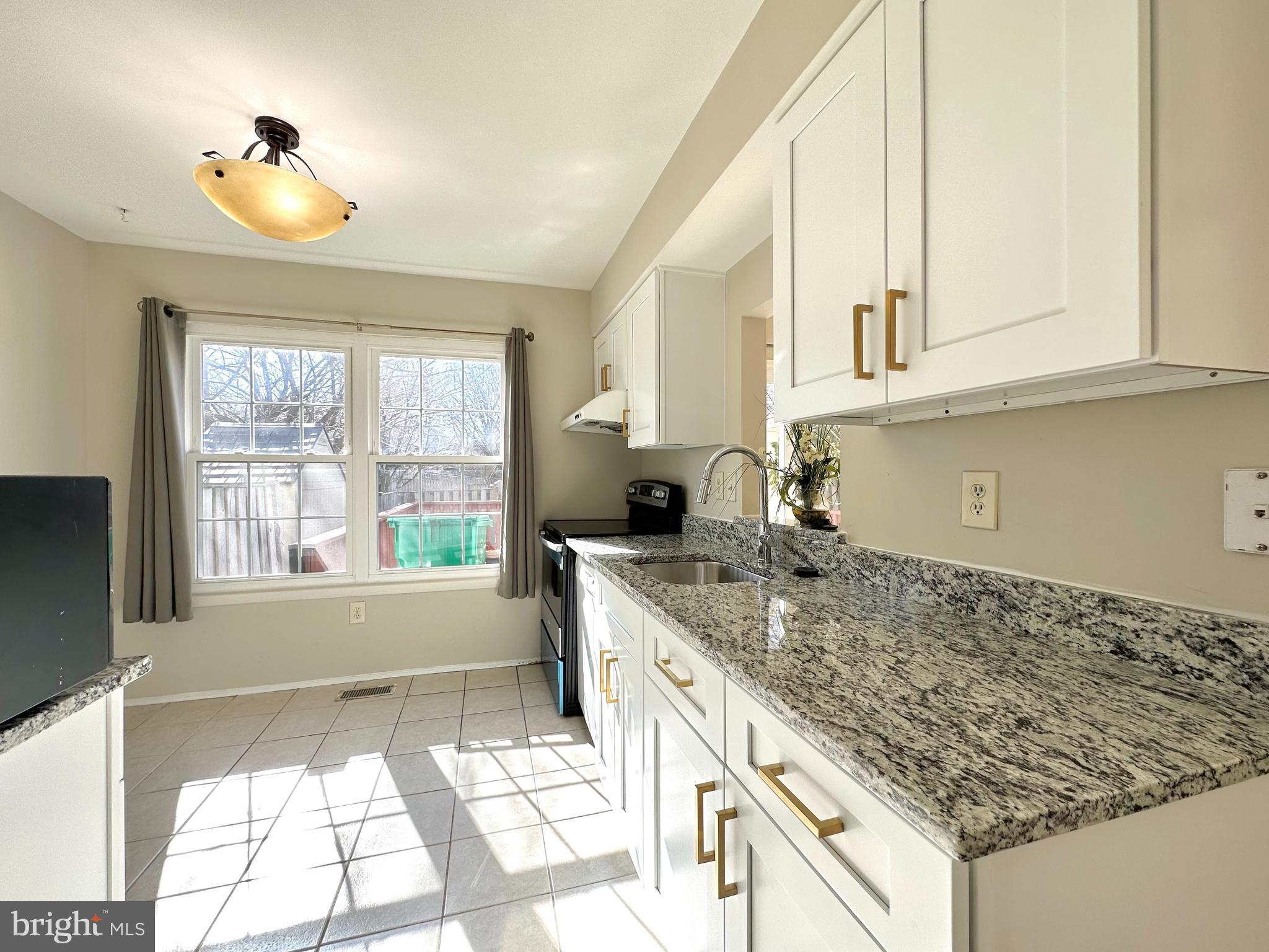 402 Carousel Court Gaithersburg, MD 20877 - Photo 11 of 29 a kitchen with granite countertop a sink and a window