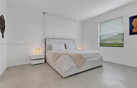 a bed sitting in a bedroom next to a window