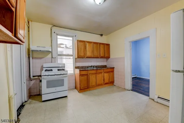 a kitchen with a refrigerator sink and cabinets