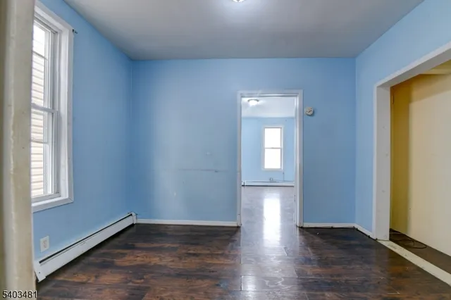 a view of an empty room with wooden floor and closet