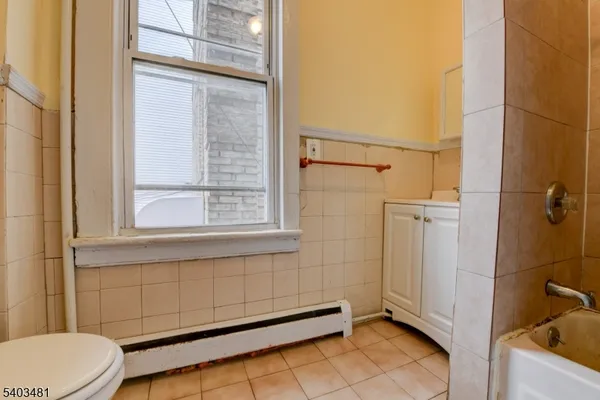 a view of an empty room with wooden floor and closet