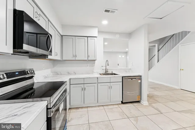 a kitchen with a sink a stove and cabinets