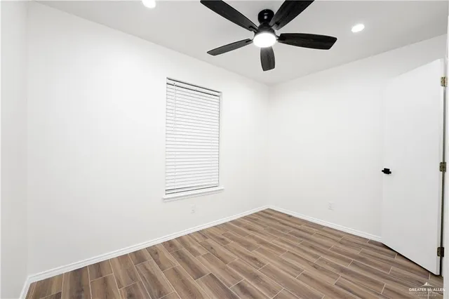 an empty room with a window and a fan