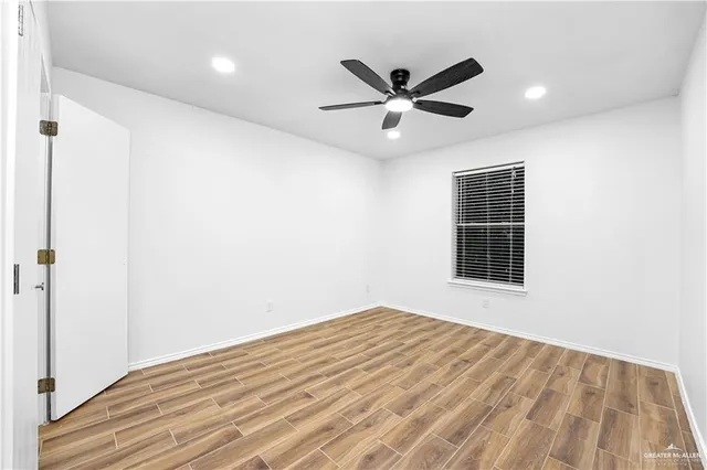 a view of a big room with wooden floor and windows