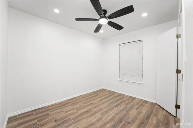 an empty room with a window and a fan