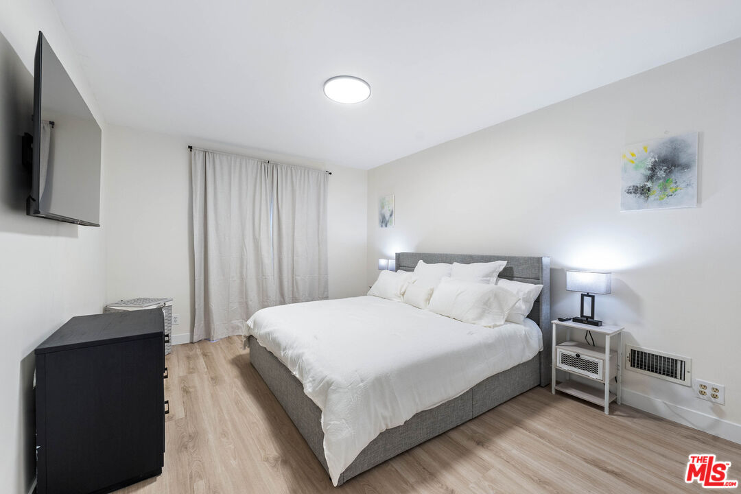 140 North Carson Road Beverly Hills, CA 90211 - Photo 18 of 28 a bedroom with a bed and a flat tv screen on a dresser