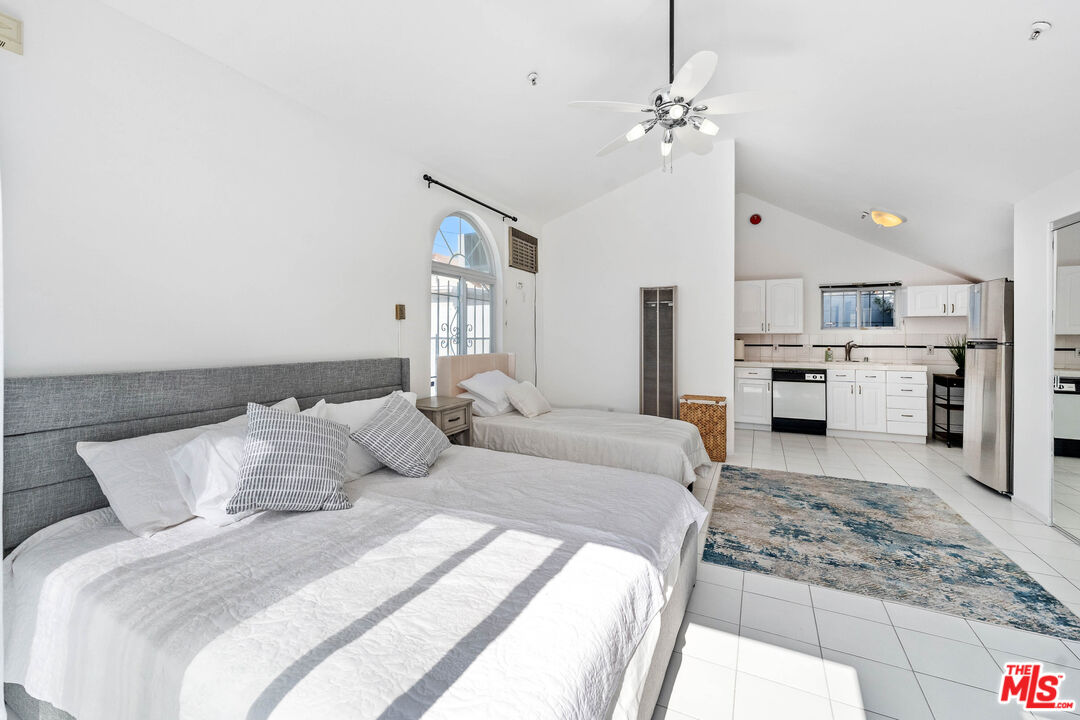 140 North Carson Road Beverly Hills, CA 90211 - Photo 21 of 28 a bedroom with a large bed and a chandelier