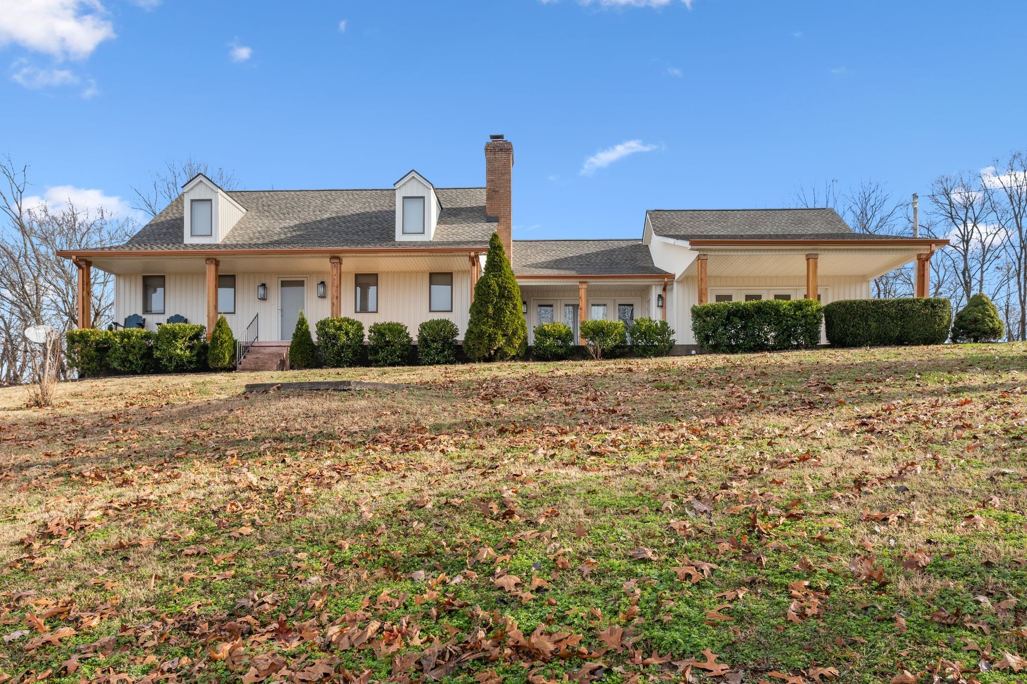 a front view of a house with a yard and trees