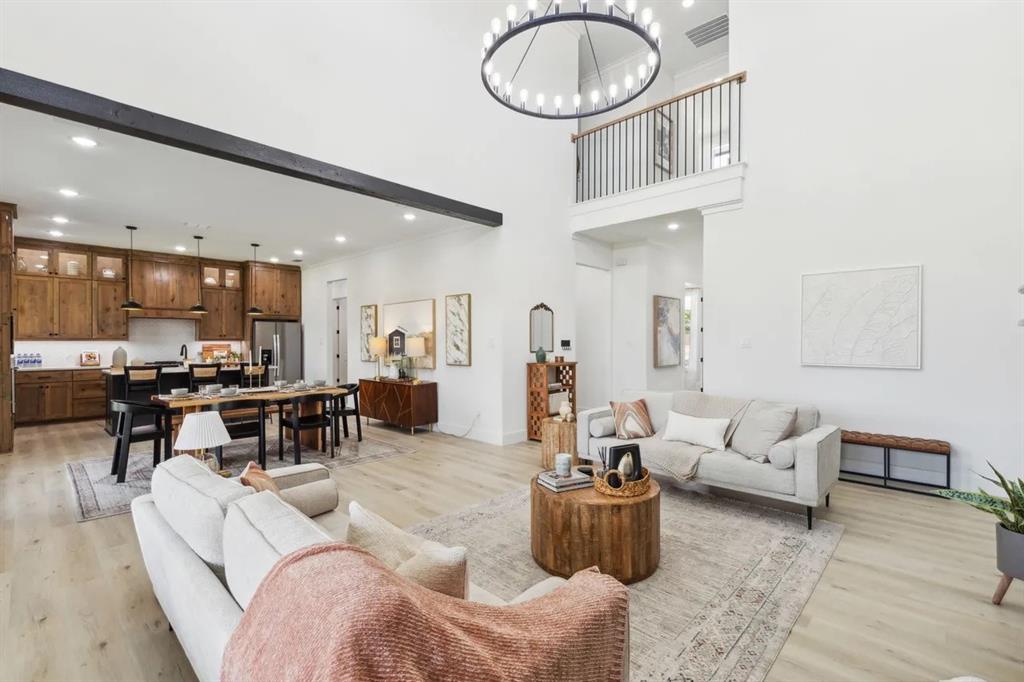 1310 Benjamin Trail Van Alstyne, TX 75495 - Photo 11 of 27 Living area featuring light wood-type flooring, a chandelier, and a high ceiling