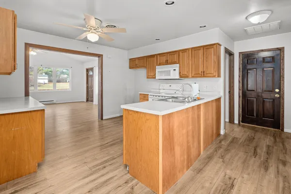 a kitchen with stainless steel appliances granite countertop a refrigerator a stove and a wooden floors