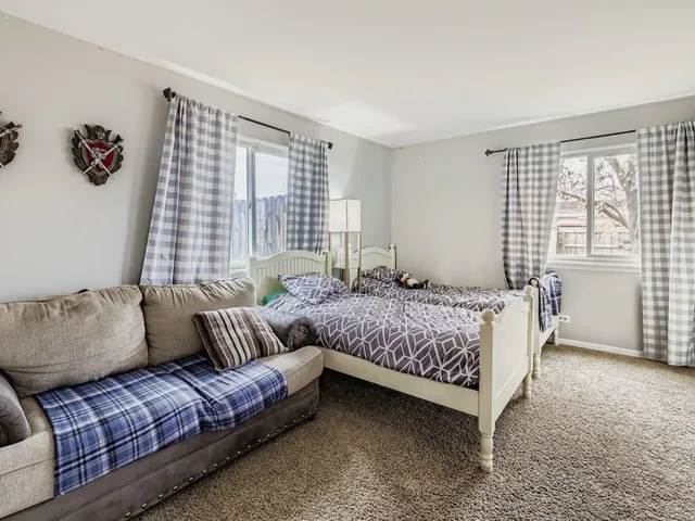 a bedroom with bed couch and window