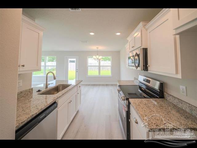 8049 Westpointe Lane, Unit 11B Pensacola, FL 32506 - Photo 4 of 5 a kitchen with sink stove and refrigerator