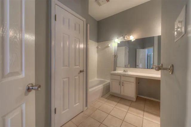a bathroom with a sink a vanity a mirror and a bathtub