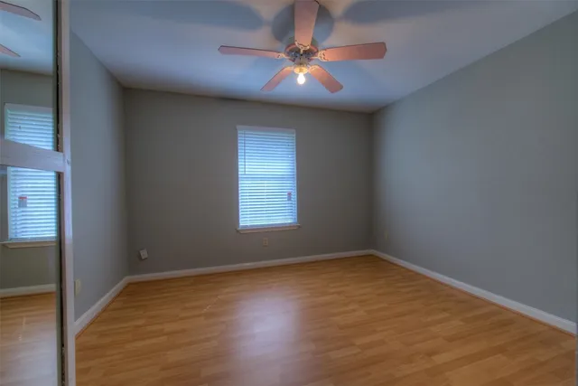 a bathroom with a toilet a sink a mirror and a window
