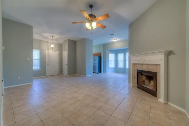 an empty room with fan and fireplace
