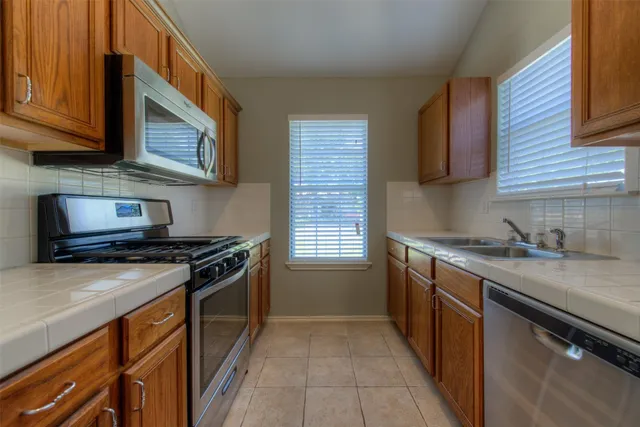 a kitchen with stainless steel appliances granite countertop a stove and a microwave